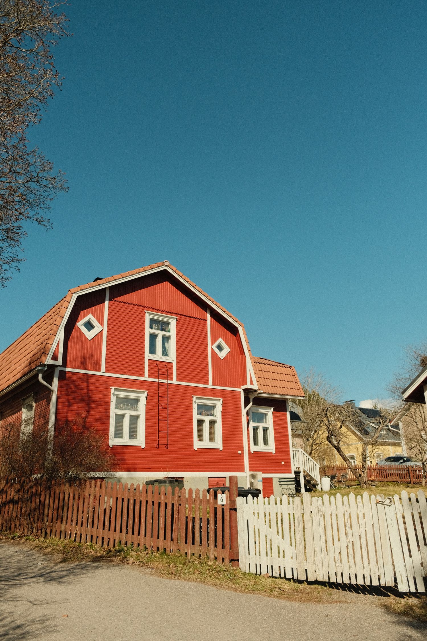 Suomalainen punainen puutalo valkoisin puittein kesäauringossa